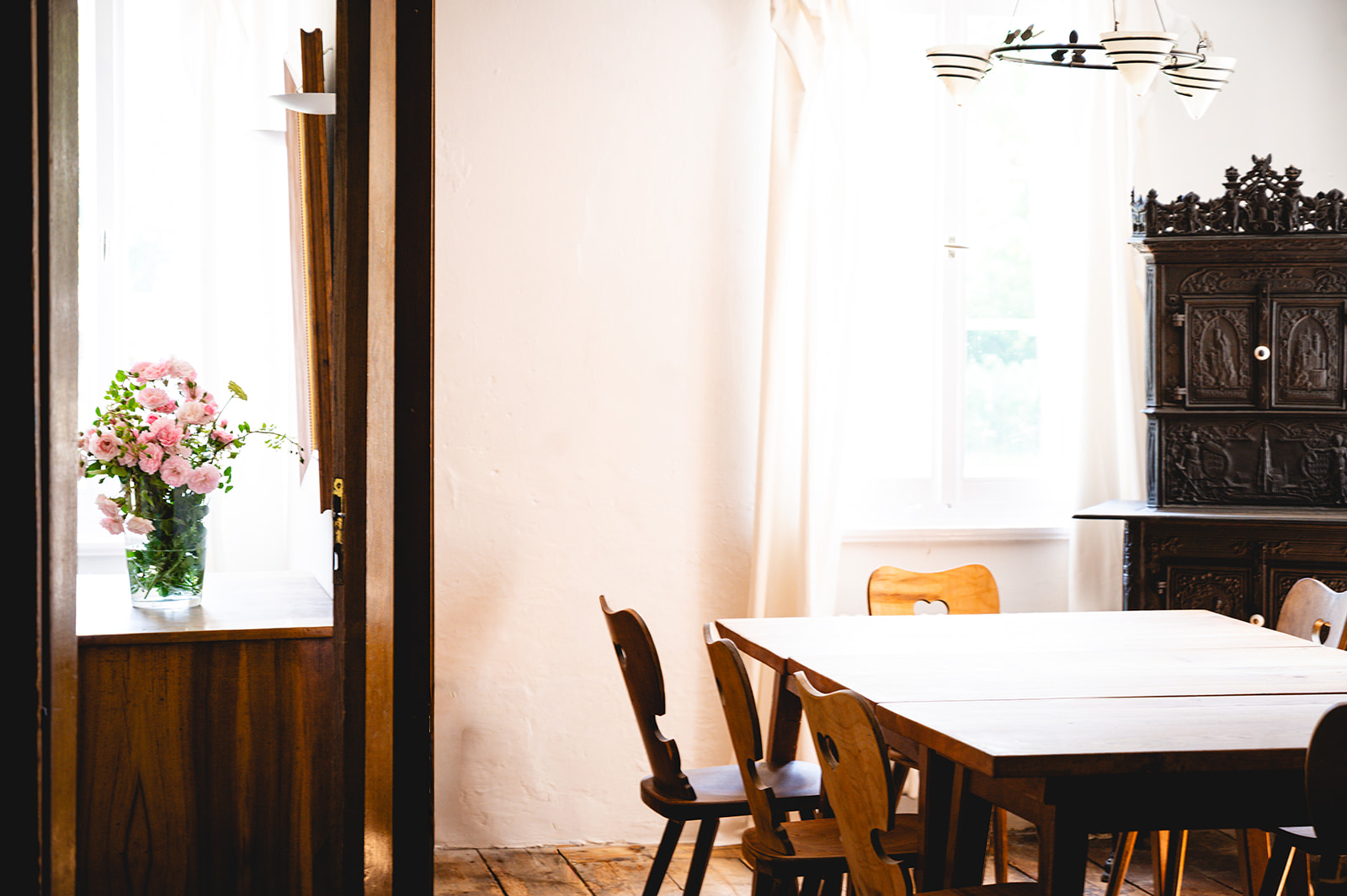 Gemütlicher Innenraum mit rustikalem Holztisch und antikem Schrank