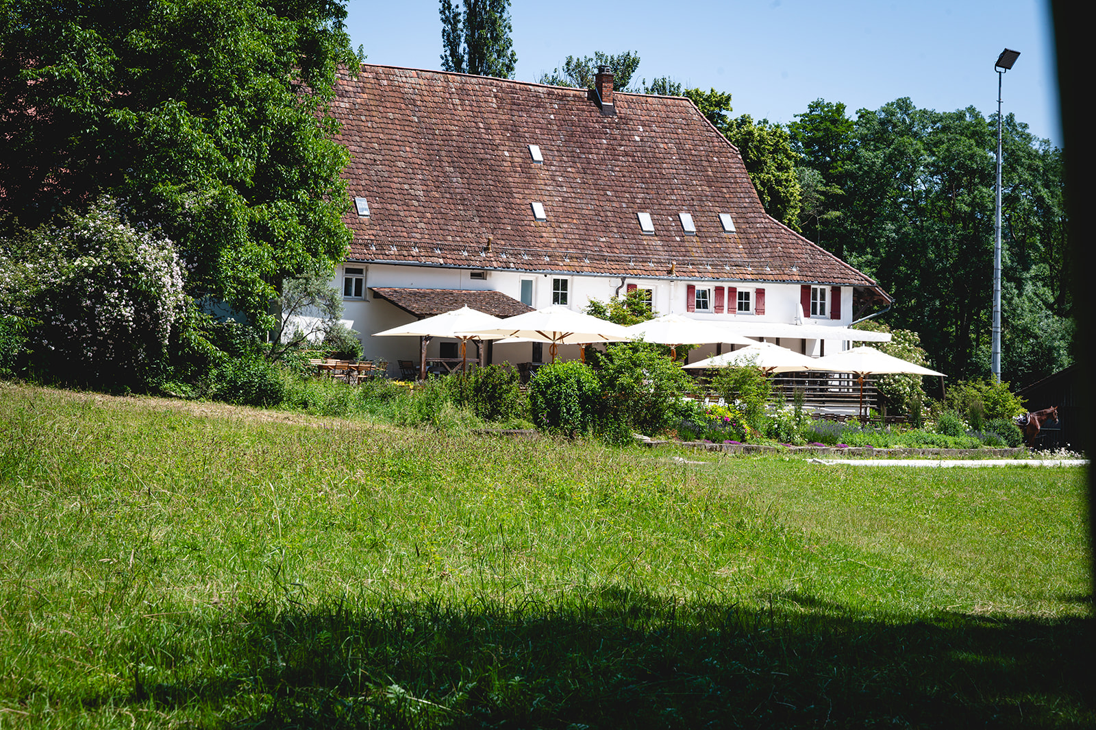 Körschmühle Außenansicht mit Terrasse und grüner Wiese