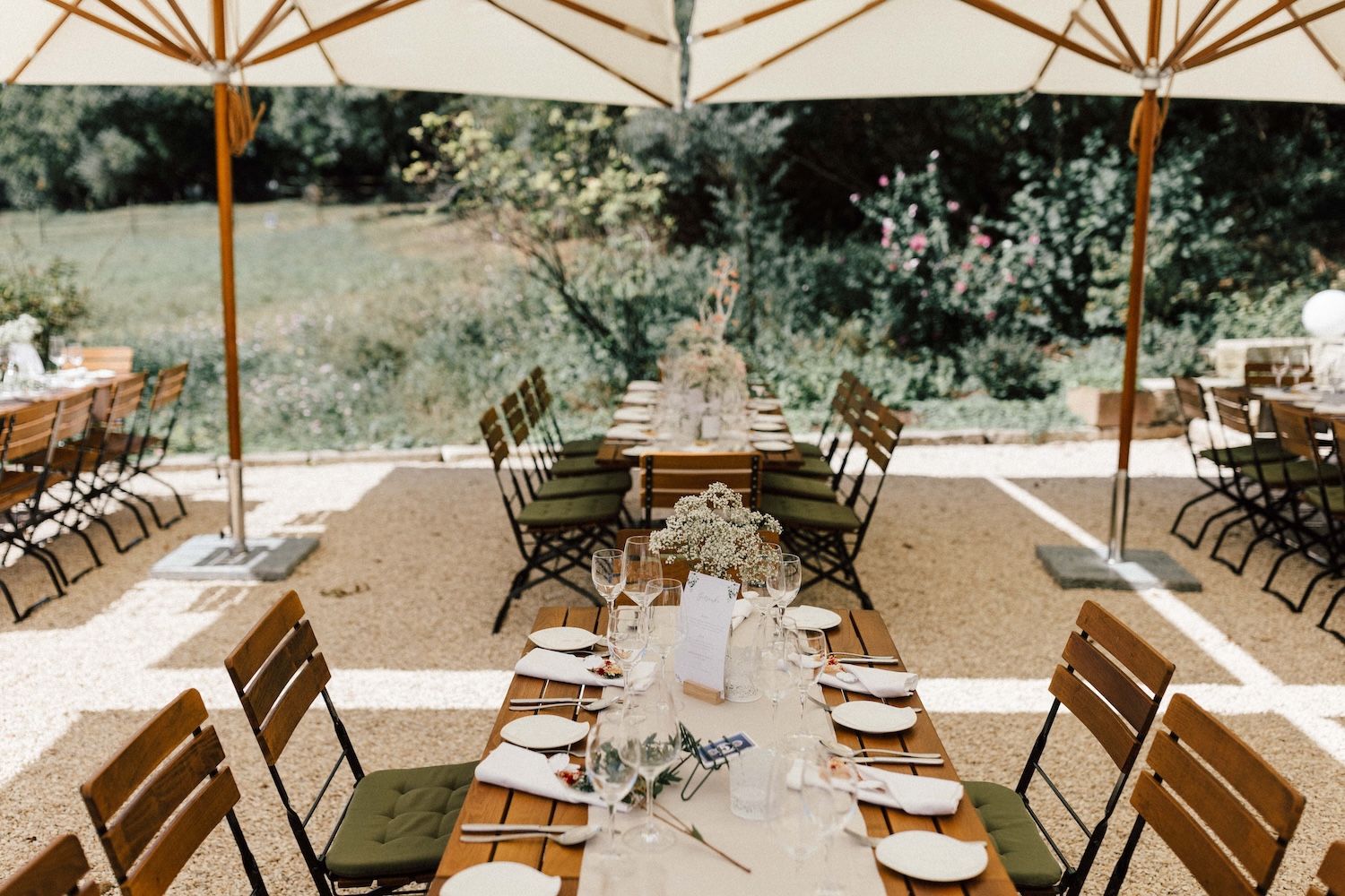 Festlich gedeckte Tische unter weißen Sonnenschirmen